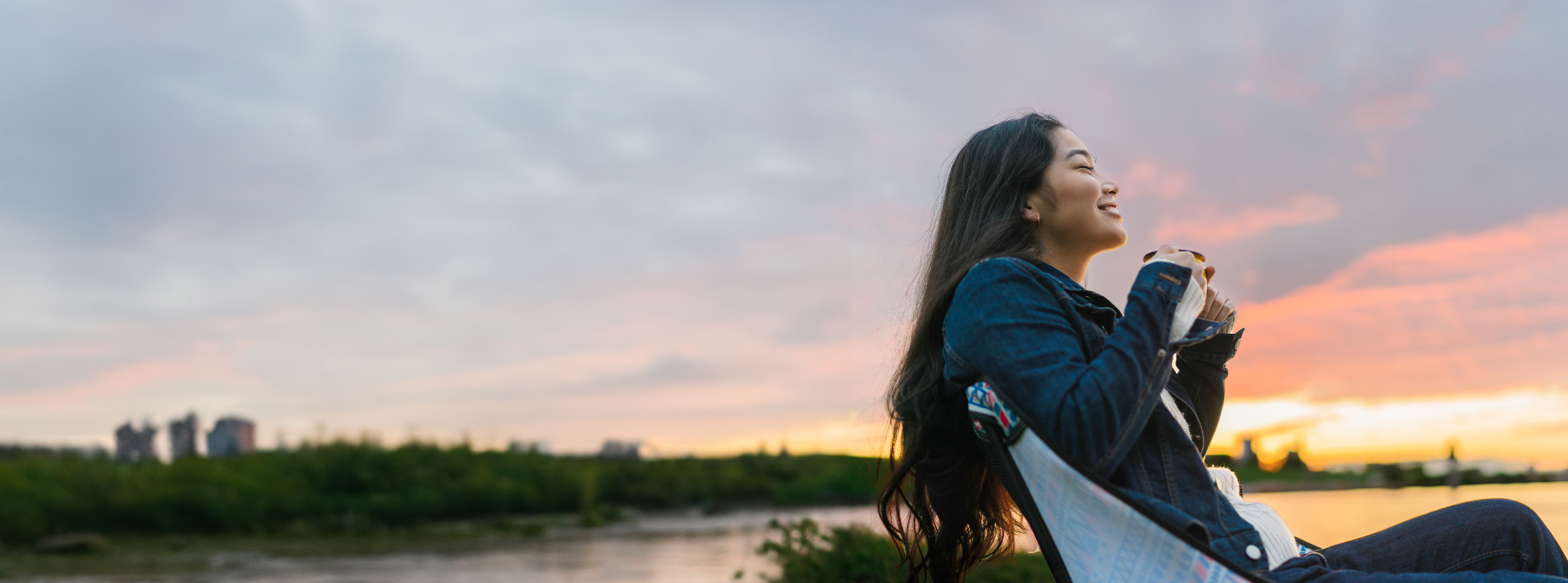 Person sitting outside with the sunset 