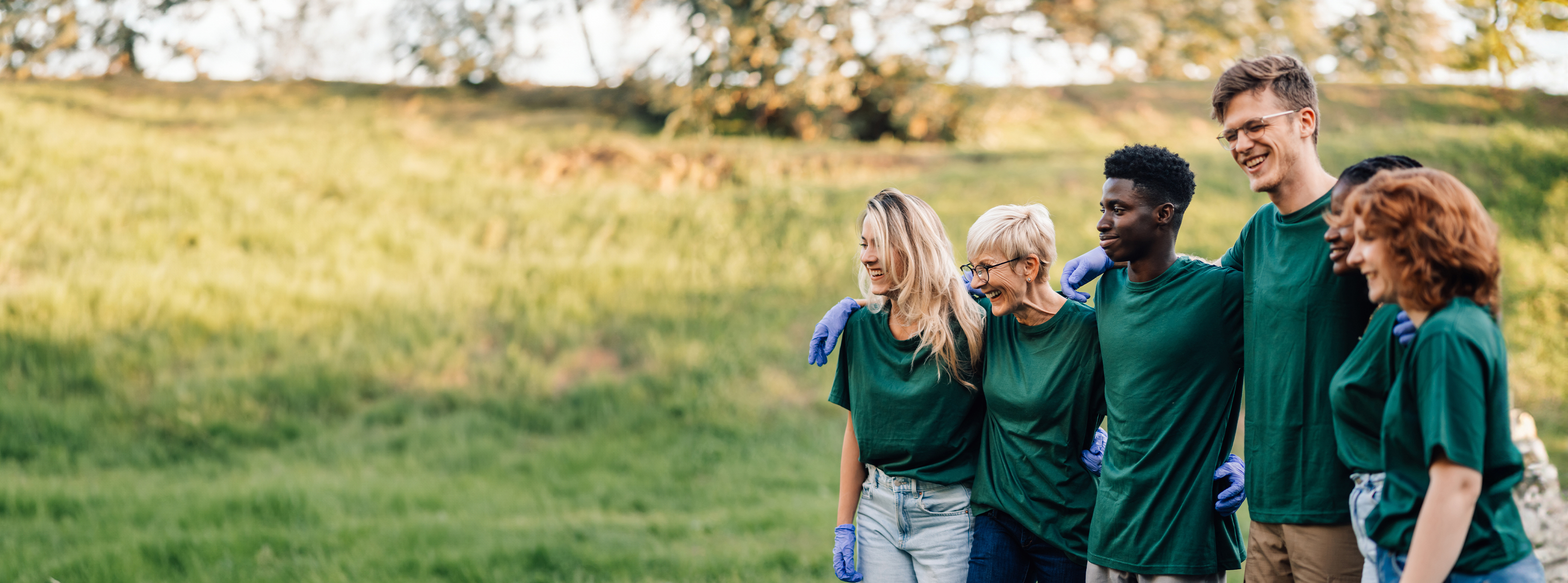 group of people in green shirts taking a photo